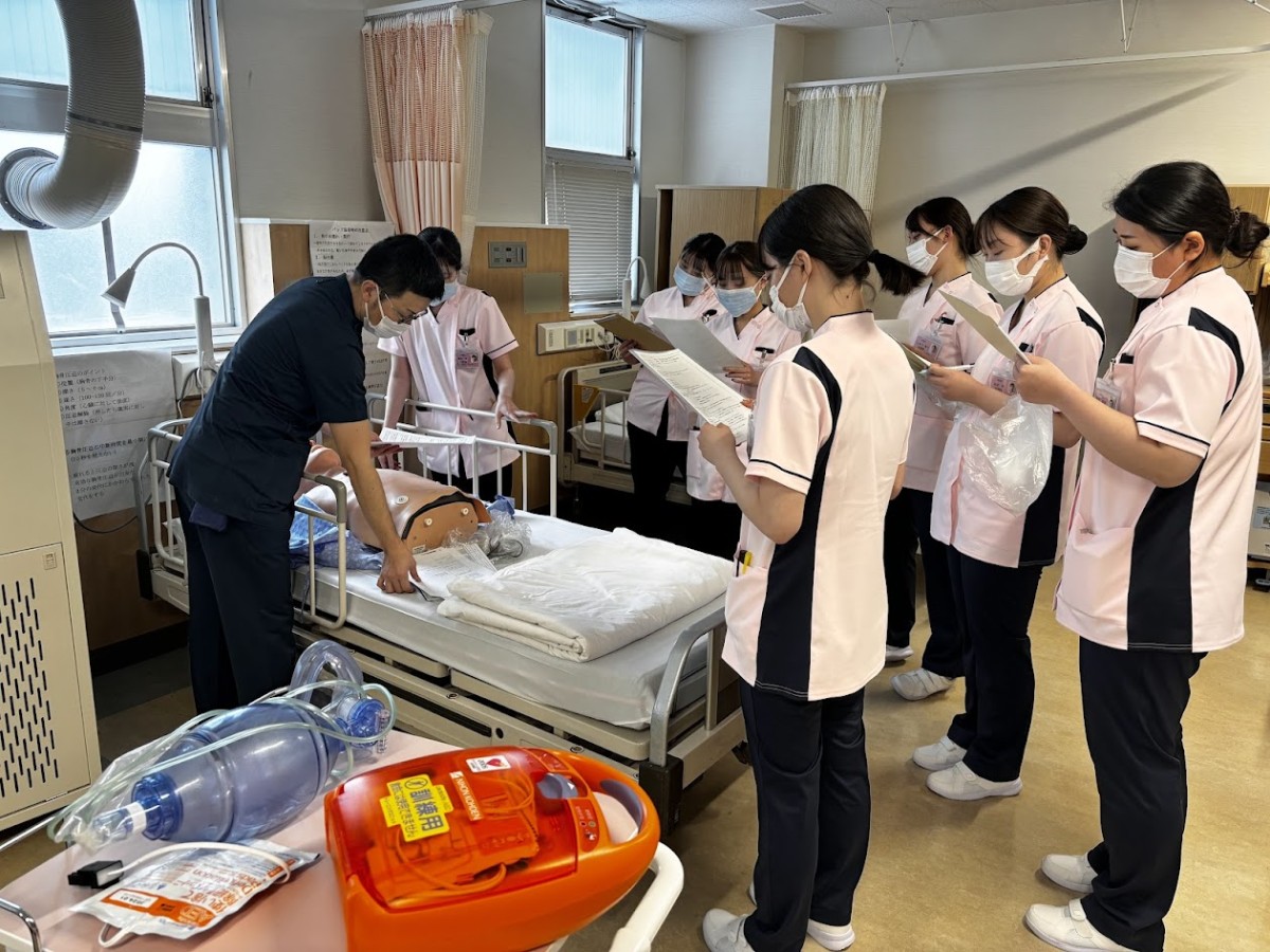 写真：他の看護師に手術着を着せてもらっている様子