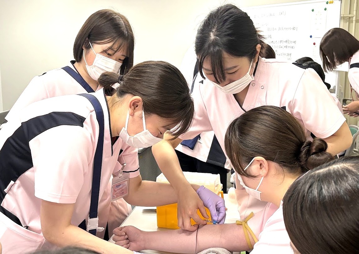 写真：看護師同士で注射器について研修をおこなっている様子